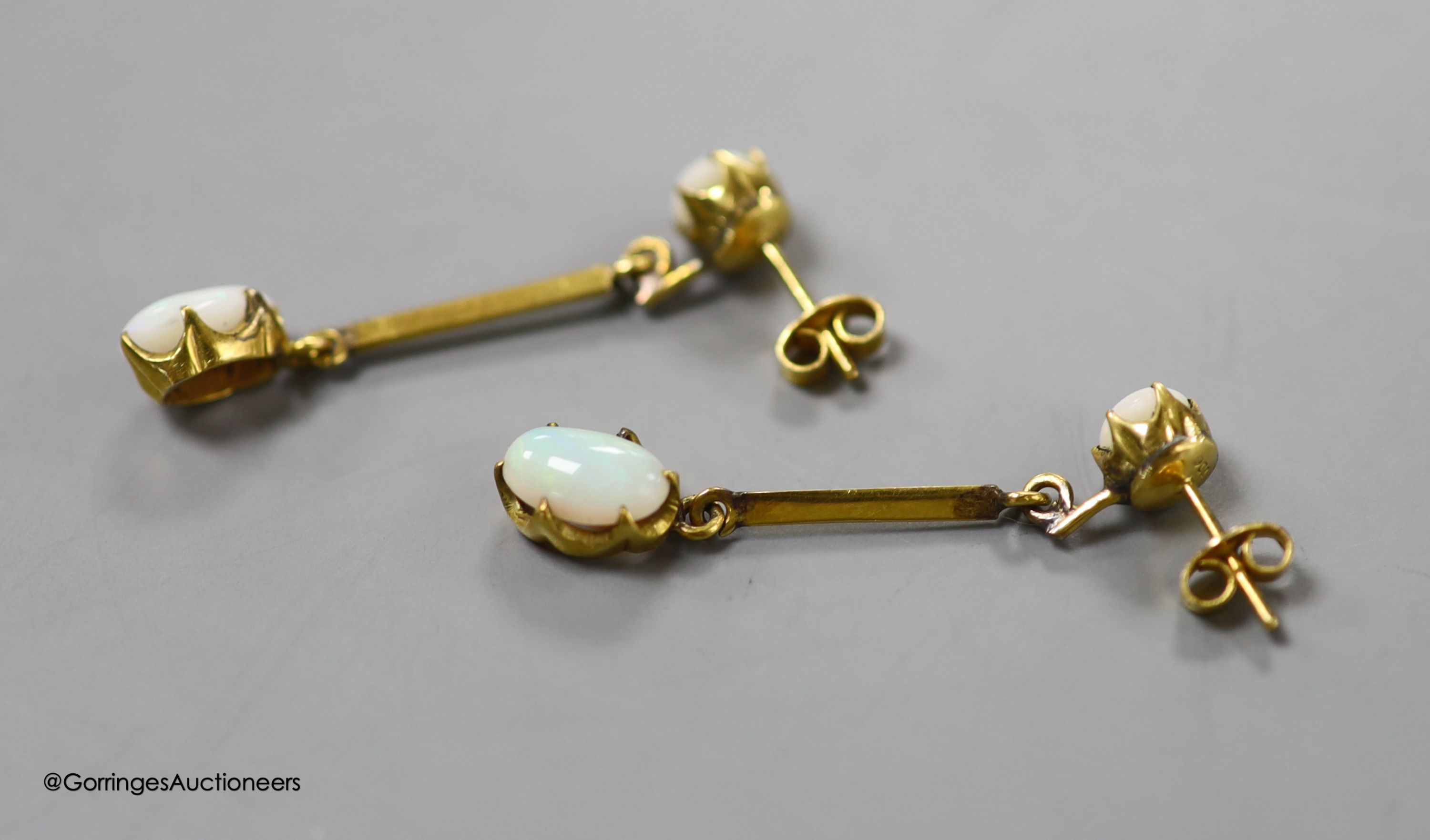 A pair of 9ct and two stone white opal set drop earrings, 36mm, gross 2.9 grams (one of the appears to be a replaced simulated opal which is also chipped).